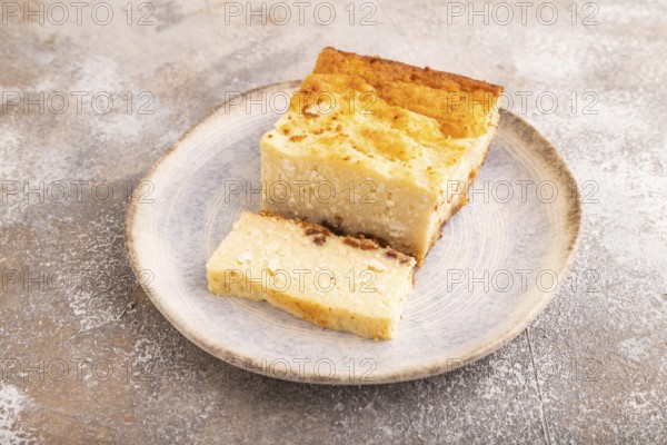 ?ottage cheese ?asserole, Curd cake, with dried apricots and raisins on brown concrete background,