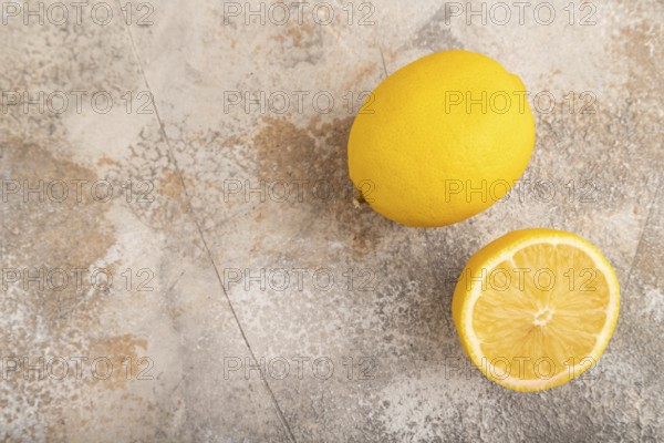 Yellow Lemon Cut in half on brown concrete background. Top view, flat lay, copy space. healthy