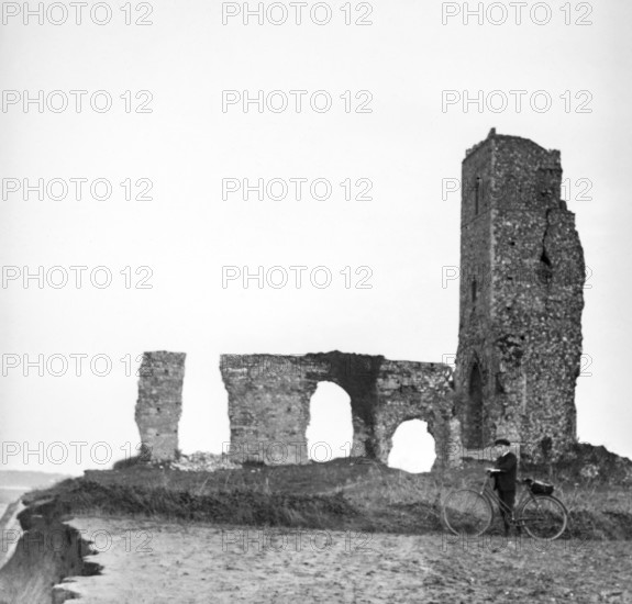 Magic lantern slide of boy with bicycle standing by ruins of All Saints church, Dunwich, Suffolk,