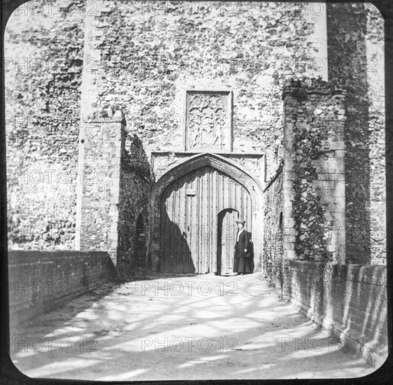 Magic lantern slide of woman standing at doorway entrance to Framingham castle, Suffolk, England,