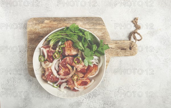 Raw meat marinated with spices and onions, for barbecue, sliced meat, pork neck, in a bowl,