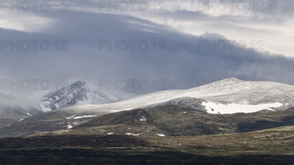 Blick auf schneebedeckte Berggipfel und baumlose Landschaft, Wolken, Pilgerweg Olavsweg, Olavsleden