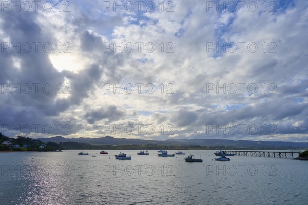 Boote auf ruhigem Wasser unter einem bewölkten Himmel bei Sonnenuntergang, Moeraki, Hampden, North