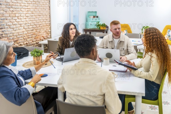 Diverse business professionals working together around a table, sharing ideas and analyzing data