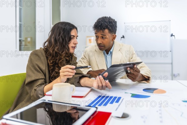 Diverse business colleagues discussing financial data and charts during an office meeting,