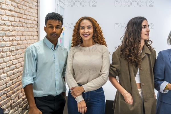 Group of multi ethnic business professionals standing together in a contemporary office, showcasing