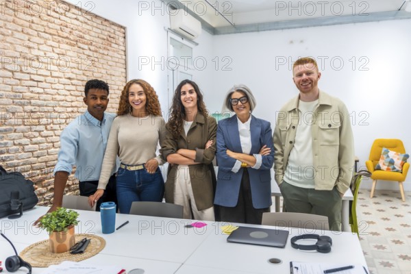 Group of multi ethnic business people posing together in a bright, contemporary office space,