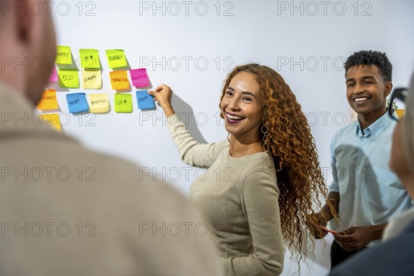 Young diverse business professionals collaborating, smiling, and brainstorming creative solutions