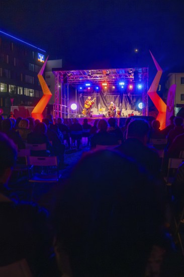 Concert at night on a colourfully illuminated open-air stage with audience, Feuernacht,