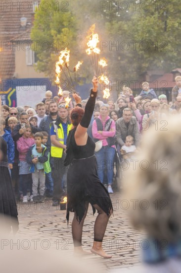 An artist performs a show with fire torches in front of a curious crowd, Feuernacht, Sindelfingen,