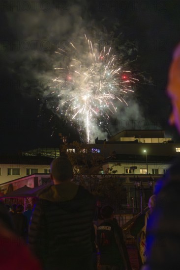 Spectacular fireworks illuminate the night sky during a celebration, people watch fascinated, Fire