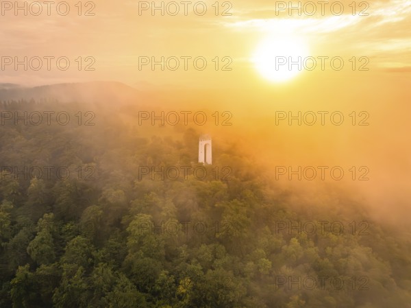 A lone tower rises out of a misty forest, illuminated by a warm sunset, Schönbergturm, Pfullingen,