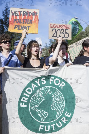 Young demonstrators with signs Welt brennt, Politik pennt und Gasausstieg: 2025 in front of the