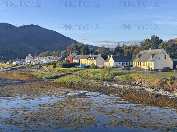 Coastal landscape with charming colourful houses and a small boat in the evening light, Dornie,