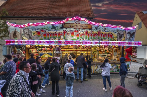 Shooting gallery in the evening at the church fair in the village of Eschenau, Middle Franconia,