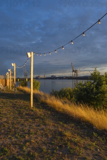 View from the outside area of a restaurant at Lankenauer Höft through a string of lights onto