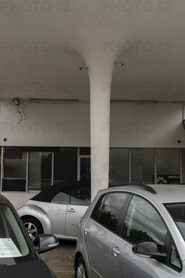 View over cars for sale on a pillar of a roof of an old petrol station or car repair shop on which