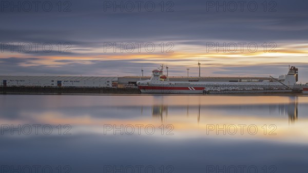 View of a ship moored at the quay in Neustadt harbour at sunset, long exposure, Weser, Bremen,
