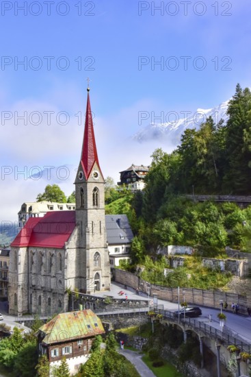 Parish church on the waterfall path in Bad Gastein, in the background the snow-covered peaks of the