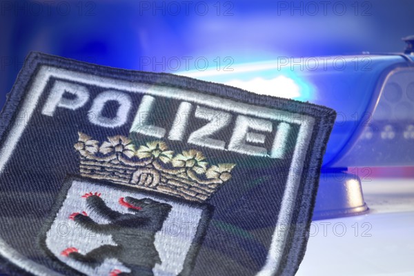 (Photomontage) Symbolic image of a police operation in Berlin: Berlin police emblem in front of