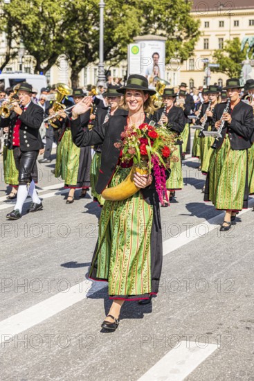 Marketender with flower-decorated cornucopia in front of the brass band from Aschheim, traditional