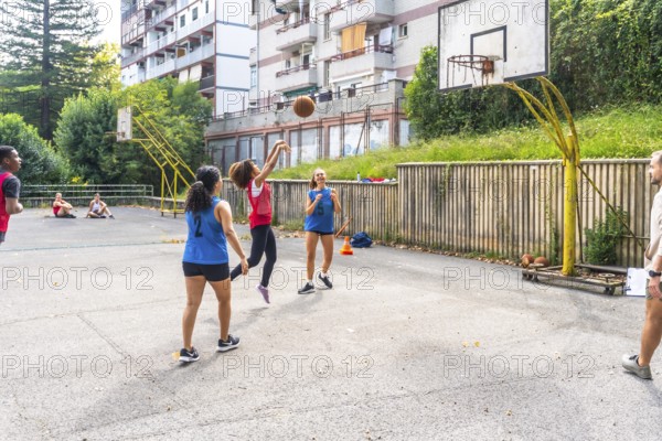 Female basketball player jumping and shooting the ball during a training session on an outdoor