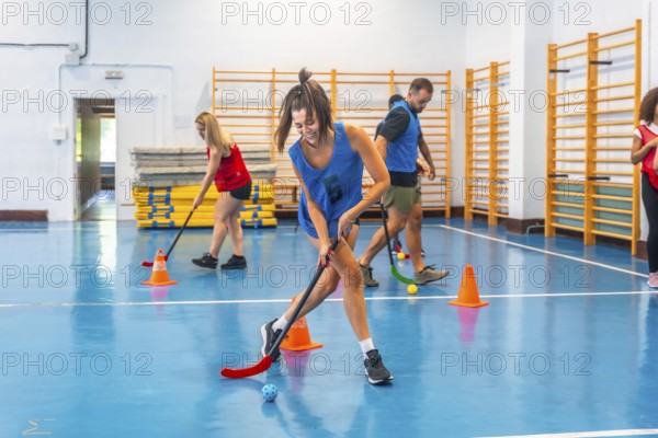 Floorball players running and practicing their stick handling skills during a training session