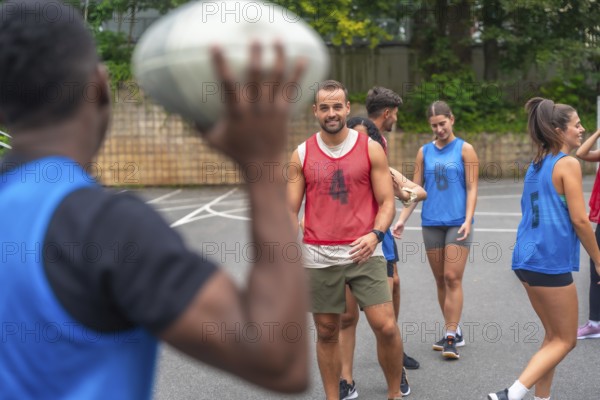 Group of athletes in sportswear engaging in passing drills while training on an outdoor court,