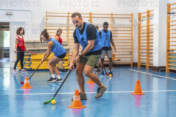 Group of athletes engaging in floorball practice, running with sticks and skillfully hitting the