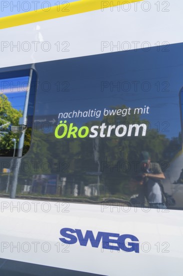 Train with sustainable ecological advertising and reflections on the window, battery Electric train