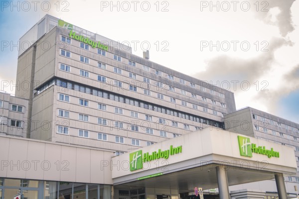 Large Holiday Inn Hotel with several floors in front of a cloudy sky, Munich, Germany