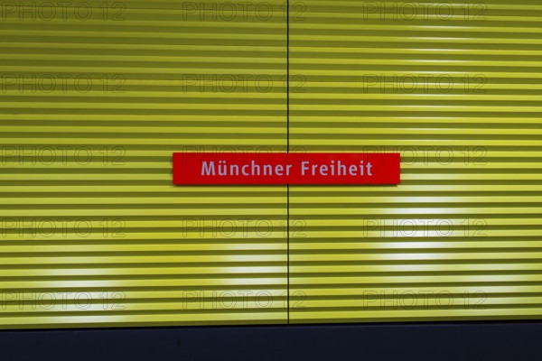Yellow underground sign with red nameplate 'Münchner Freiheit', Munich, Germany