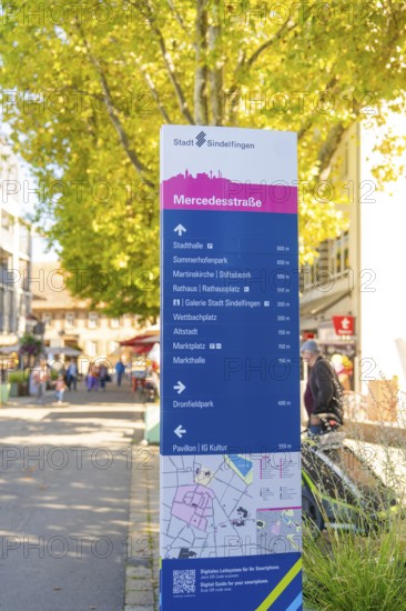 Urban signpost with distances to various destinations in a sunny neighbourhood, Sindelfingen,