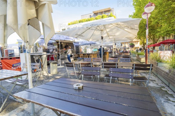 Empty outdoor café with tables and chairs under parasols, sunny and inviting, Sindelfingen,