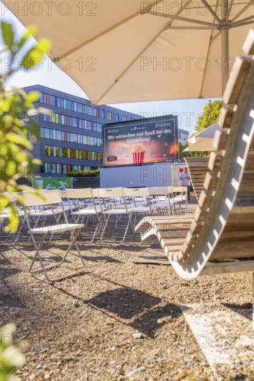 Seating and screen under parasols, sunny urban outdoor area, open air cinema Sindelfingen, district