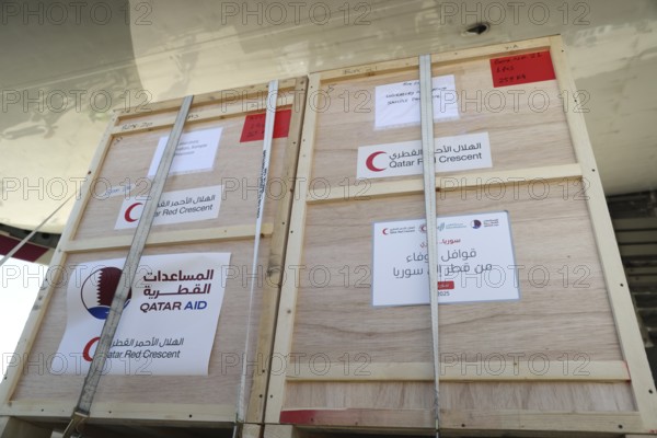 Relief workers unload boxes of medical aid provided by Qatar at Damascus International Airport,