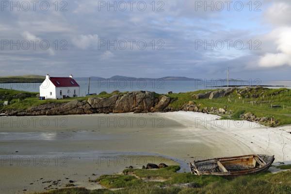 A lonely house and an old boat on a quiet, rocky beach, Isle of Barra, Hebrides, Scotland, United