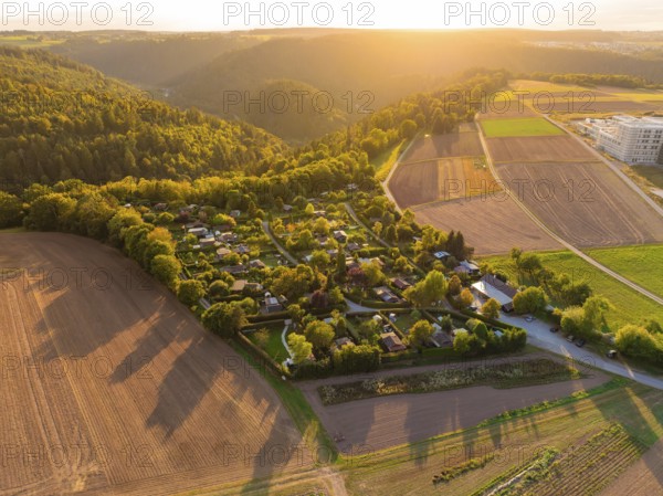 Campsite between forests and fields at sunset with rolling hills, small town Perle Calw, Black