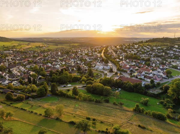 Spacious residential area with open fields and forests at sunset, small town of Perle Calw, Black