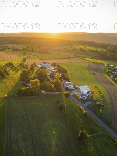 Idyllic landscape with fields and buildings in the warm light of the sunset, small town of Perle