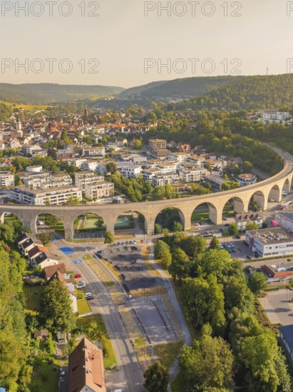Viaduct running through an urban area over hills and through natural landscape, small town of Perle