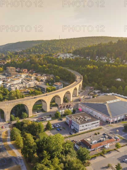 Imposing viaduct over a town with surrounding hills and forest at dusk, small town Perle Nagold,