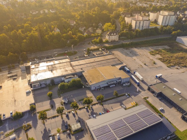 Wide view of an industrial area with car parks and solar panels on the roofs, small town of Perle