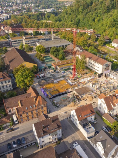Construction site in the middle of an urban environment with crane and surrounding building