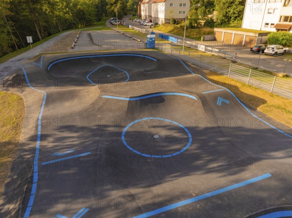 A pump track marked with blue lines in a green, urban environment, pump track, Nagold, Black