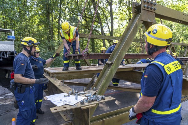 Construction of a temporary bridge over a slipped road crossing a stream, by the bridge