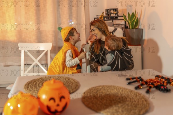 Mother and children wearing halloween costumes, enjoying time together at home, surrounded by