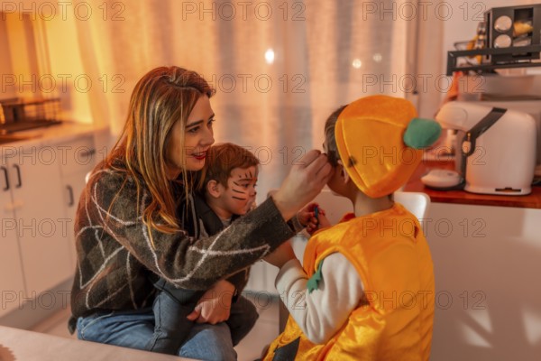 Mom applying makeup on her kids, joyfully preparing costumes for halloween night, creating fun