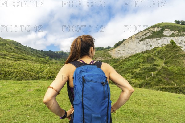 Female hiker admiring the breathtaking view of the sakoneta beach and flysch cliffs in zumaia,