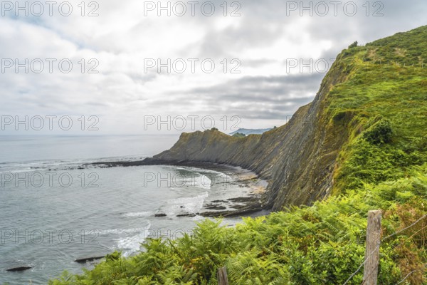 Breathtaking view of the flysch cliffs meeting the ocean waves at sakoneta beach in zumaia, a